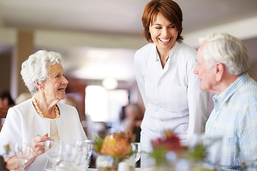 server talking to elderly couple