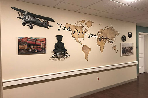 Hallway decor with vintage plane, train, and map saying Find joy in your journey.