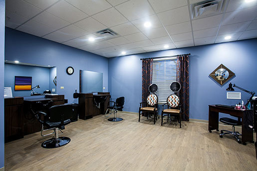 Spacious salon with styling chairs, mirrors, and a window with curtains.