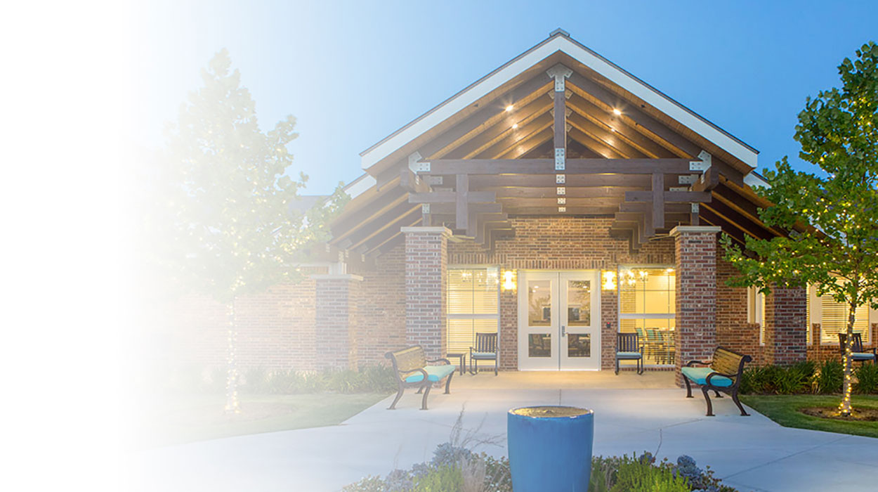 Building facade with wooden beams, brick pillars, benches, and a large entrance.