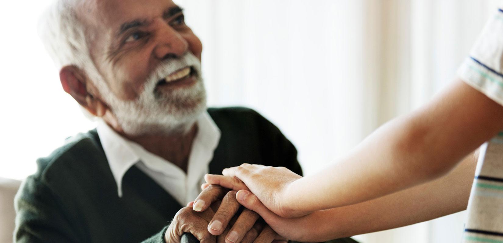 elderly man with younger hands at The Delaney at Lake Waco senior living