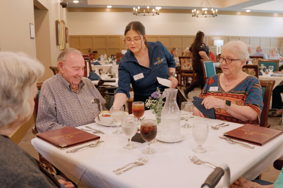 Dining staff serving a table of seniors